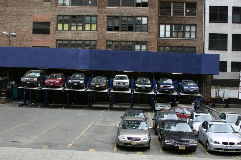 2006-05-06 11:50:32 ** New York ** Um den Platz auf den wenigen Parkplätzen optimal zu nutzen, wird hier doppelt belegt. Die Autos unter der Bühne müssen umgeparkt werden, um an die oberen Autos zu kommen.