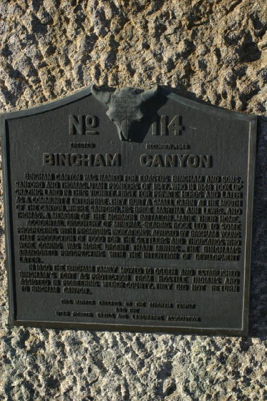 2005-05-22 19:27:16 ** Utah ** Übersetzung des Texts auf der Tafel: 'Bingham Canyon wurde nach Erastus Bingham und seinen Söhnen Sanford und Thomas, Utah-Pionieren von 1847, benannt. 1848 haben sie das Land in dieser Umgebung als Weideland genutzt, zuerst für ihre eigene Herde und später für als Gemeinschaftsunternehmung. Sie bauten eine kleine Hütte am Eingang des Canyons, wo Sanford, seine Partnerin Martha Ann Lewis und Thomas, ein Mitglied im Mormon Battalion wohnten.
Der zufällige Fund von Gestein mit Mineralien führte zur aussichtsreichen Schürfung. Auf den Rat von Brigham Young, daß Landwirtschaft zur Ernährung der Siedler wichtiger als Bergbau war, haben die Binghams die Schürfarbeiten mit der Absicht auf spätere Entwicklung eingestellt.
1850 zog die Bingham Familie nach Ogden und baute dort Bingham's Fort als Schutz gegen Indianer und half bei der Pionierarbeit für Weber County. Sie kehrten nicht zum Bingham Canyon zurück.'