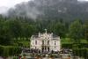 Schloß Linderhof mit wolkenverhangenen Bergen im Hintergrund.